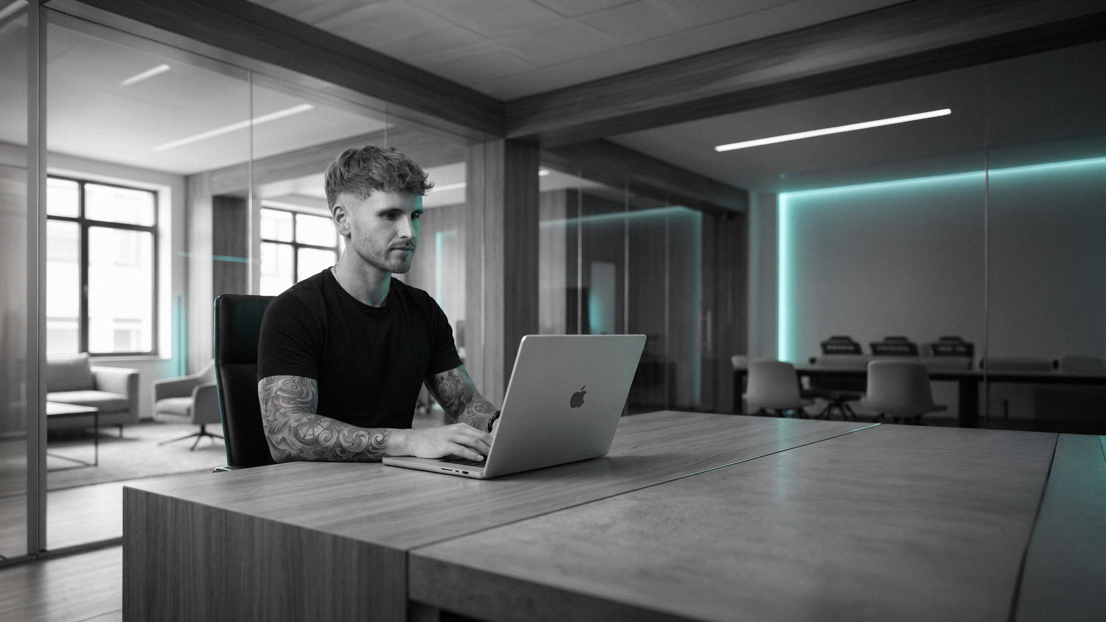 Dominic Hoferer am MacBook im modernen Studio-Büro — CRƎAITIV studio, Lustenau